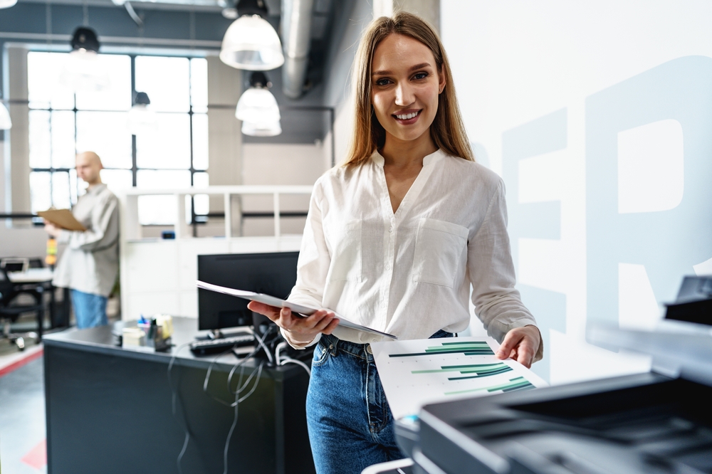 woman at the printer. controlling print concept.