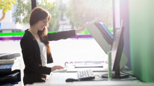 A young student at a copy center taking some copies. Concept of managed print services for schools.